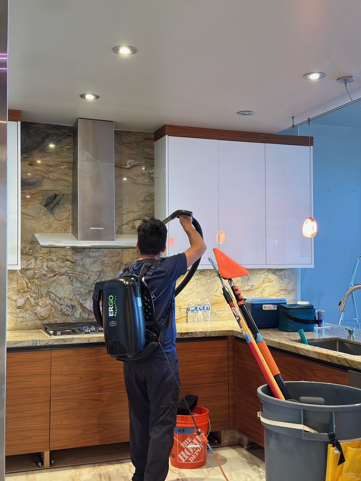 MEI team member vacuuming upper cabinets during detail cleaning